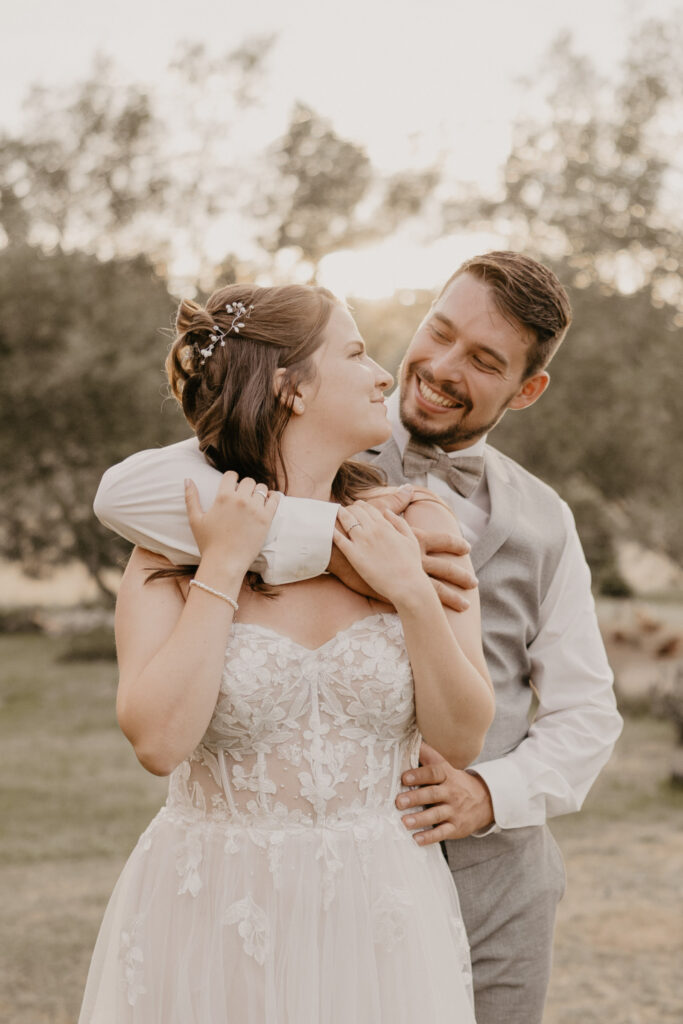 golden-hour-shoot-braeutigam-umarmt-braut-von-hinten-quer-hochzeitsfotograf-zwettl
