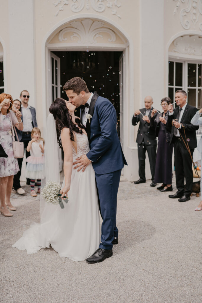hochzeitsfotografin-baden-brautpaar-kuesst-sich-vor-orangerie-seifenblasen