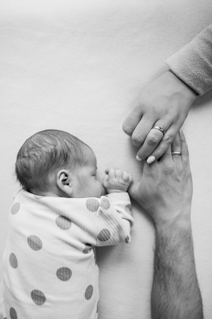 newborn-shooting-baden-bei-wien-eltern-halten-hand-baby-sw